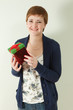 Cute redhaired woman holding holiday present