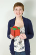 Cute redhead woman holding red gift box