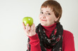 Smirking woman holding green apple