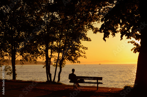 Photo: Man Sitting On Bench During A Beautiful Sunset Man Sitting On Bench During A Beautiful Sunset