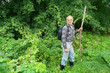An elderly man with a backpack tourist goes into the thickets