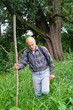An elderly man with a backpack tourist goes into the thickets