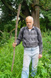 An elderly man with a backpack tourist goes into the thickets