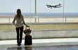 Girl at the airport window looking to the ocean
