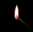 match bursting into flame against a black background