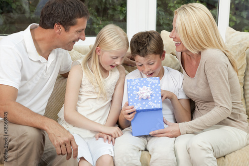 Photo: Happy Family Boy Child Opening Birthday Present At Home Happy Family Boy Child Opening Birthday Present At Home