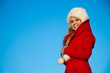 portrait of woman in red coat blue backgound