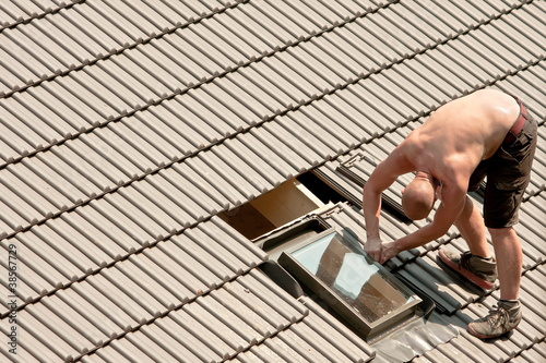 Photo: Roofer mounting a window Roofer mounting a window