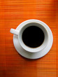 Cup of coffee on bamboo mat