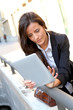 Young woman connected on internet in town Young woman connected on internet in town