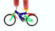 Fingers ride on toy bike, then press on it and moves away