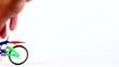Hand does tricks on toy bicycle, jump and rotate it around