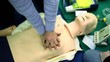 Person trains to do chest compressions on mannequin