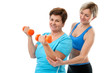 Senior woman doing fitness exercise with help of trainer in gym