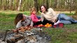Family lay on grass, plates with fruit are near them Family lay on grass, plates with fruit are near them