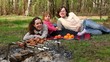Family lay on grass, plates with fruit are near them Family lay on grass, plates with fruit are near them