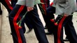Military men ascend on stairs with flowers