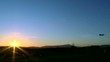 Flugzeug landet vor untergehender Sonne