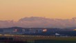 Flugzeug landet im Abendlicht vor Alpenkulisse
