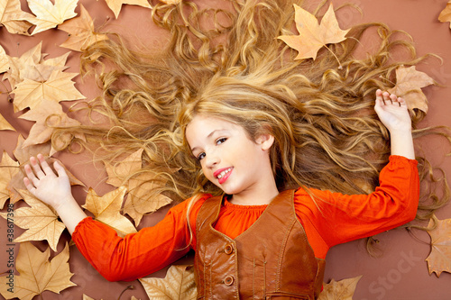 Photo: autumn fall little blond girl on dried tree leaves autumn fall little blond girl on dried tree leaves