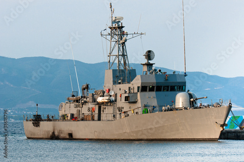 Photo: Big battle ship in the dock against blue sky and mountains Big battle ship in the dock against blue sky and mountains