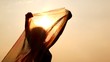 woman with thin shawl in hands which waves on wind