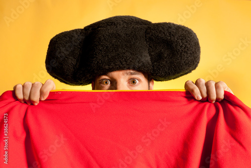 Photo: Bullfighter afraid with big montera hidden behind cape humor Bullfighter afraid with big montera hidden behind cape humor