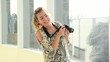 Young beautiful teen taking pictures with camera in the hall