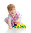 Cute little boy is playing with colorful train isolated on white