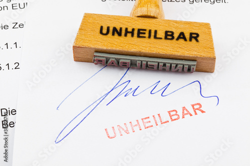 Foto: Holzstempel auf Dokument: Unheilbar Holzstempel auf Dokument: Unheilbar