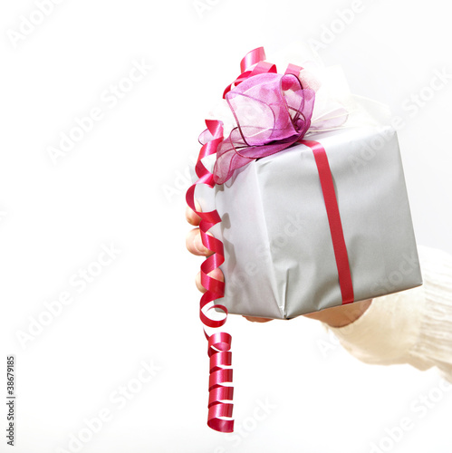 Photo: Ein Geschenk mit Schleife wird gehalten Ein Geschenk mit Schleife wird gehalten