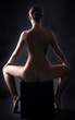 Naked   attractive sporty woman siting backwards