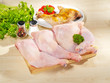 Fresh raw and roasted chicken legs arrangement on cutting board
