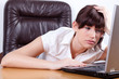 Tired young businesswoman falling asleep in her office