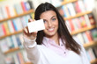 smiling young female showing a business card  -  copy space.