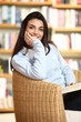smiling female student with book in hands looking at camera. On