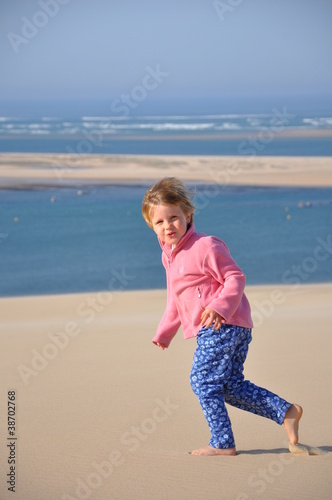 Photo: Fillette courant dans le sable Fillette courant dans le sable