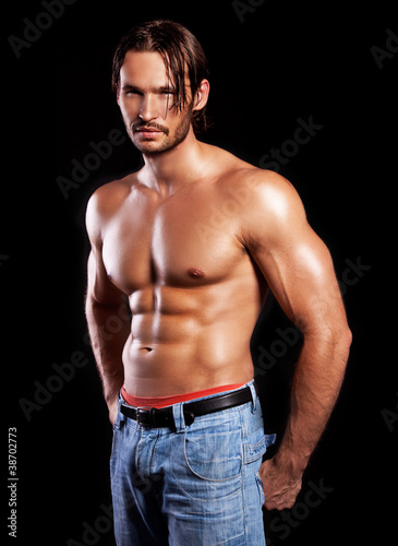 Photo: handsome powerful muscular man isolated on black handsome powerful muscular man isolated on black