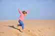 Fillette sautant d'une dune
