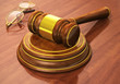 Wooden gavel and eyeglasses on table