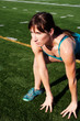 Female runner stretching on athletic field