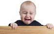 Foto: crying young child holding wooden board crying young child holding wooden board