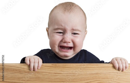 Foto: crying young child holding wooden board crying young child holding wooden board