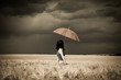 Girl with umbrella at field in retro style