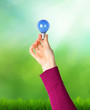 Hand supporting a light bulb