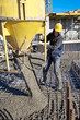 Builder worker pouring concrete at construction site