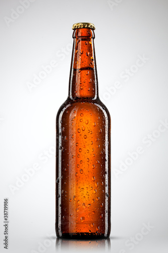 Photo: Beer bottle with water drops isolated on white Beer bottle with water drops isolated on white