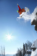 Snowboarder jumping against blue sky