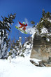 Snowboarder jumping against blue sky