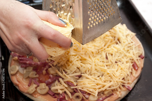Photo: Pizza preparation - a grater of solid cheese Pizza preparation - a grater of solid cheese